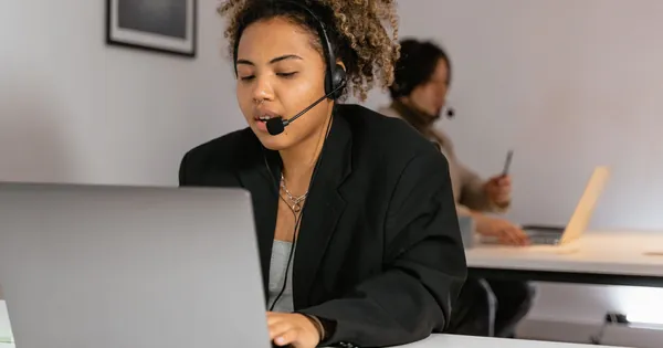 Nhân viên hỗ trợ làm việc trên laptop, tượng trưng cho xử lý đơn hàng Like360